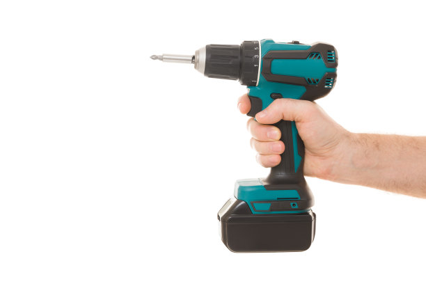 年轻的成年男子手握和显示深黑绿色专业电池螺丝刀孤立在白色背景。特写镜头。维修工具。侧视图。图片下载
