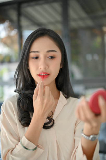 一个美丽的千禧一代亚洲女性的肖像，涂着红色的口红，化妆图片下载