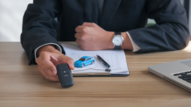 特写手给车钥匙和贷款信用金融，租赁和租赁的概念。汽车保险单签名。房屋所有者保险文件。图片下载