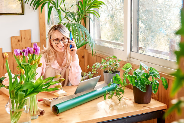女花匠在花店接受手机订单。花交付。小型企业的社交媒体。图片下载