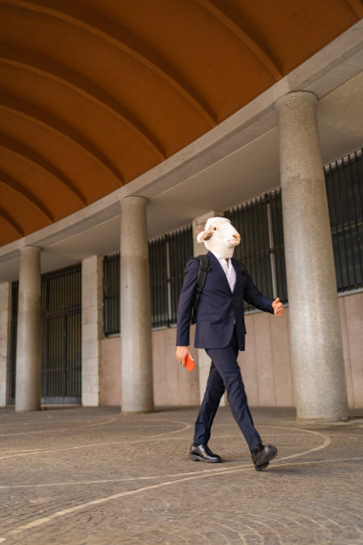 垂直照片的商人羊头快速走到工作，手里拿着手机图片下载