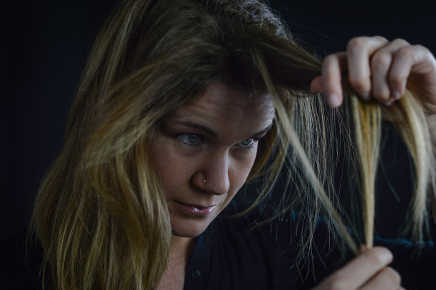 一个美丽的金发女人的肖像集中通过她的头发分叉或白发图片下载