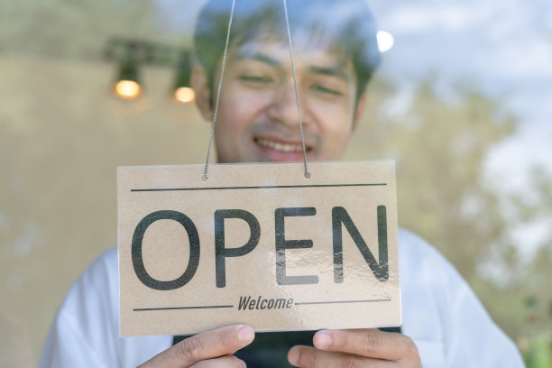 老板把开业第一天的招牌从关门改成了营业。保证安全，清洁，戴防护口罩，开咖啡店。接受新常态概念。图片下载