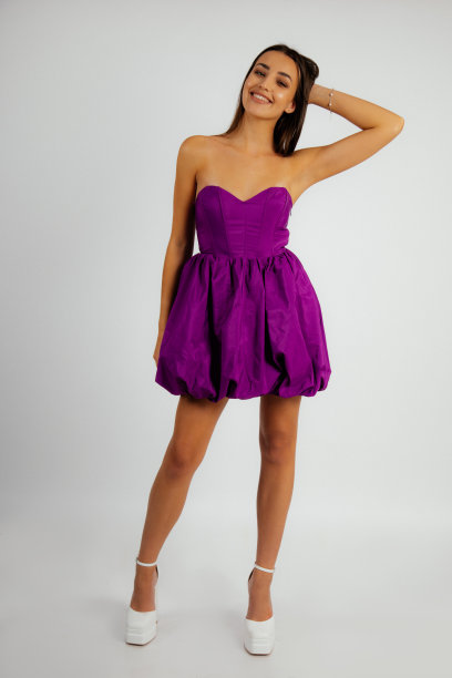 垂直长发年轻微笑的黑发女人在紫色连衣裙裸露的肩膀，鞋子看着相机图片下载
