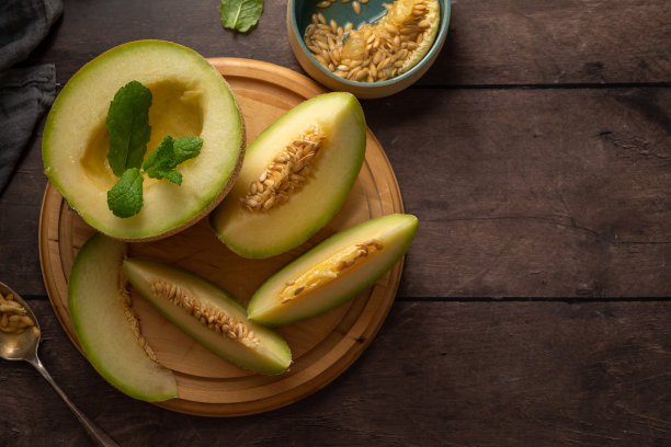 哈密瓜，深色背景的瓜果片。健康零食或甜点，复制空间图片下载