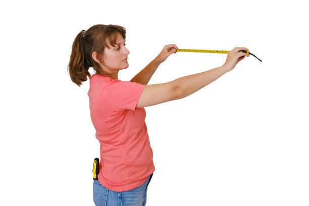 一名妇女在一间新公寓里测量墙壁的长度，公寓被隔离在白色背景上。维修工作的距离测量图片下载