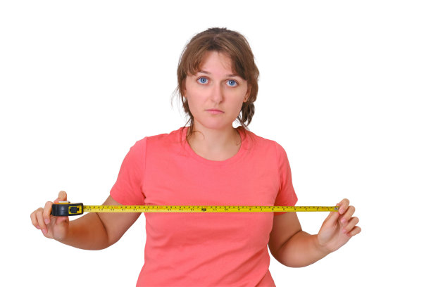 在白色背景上隔离的新公寓维修中进行独立的不确定测量。年轻女子自己痛苦地测量着房子里的距离图片下载