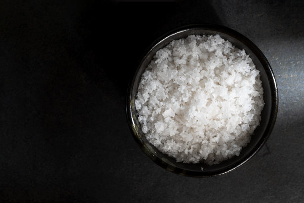 海盐晶体碗在黑石桌上。图片下载