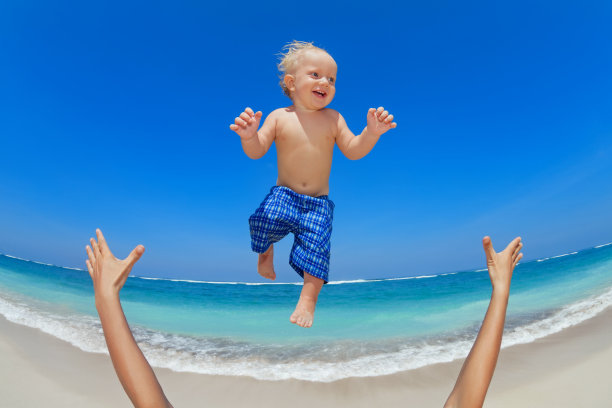 父亲把一个快乐的孩子抛向空中图片下载