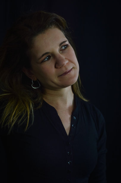 一个美丽的金发女人的肖像谁看起来好奇侧倾斜她的头图片下载