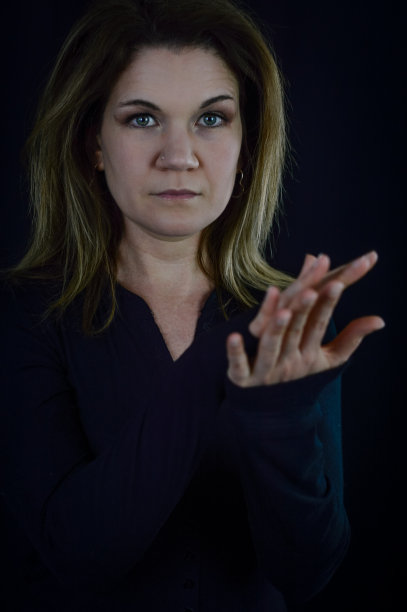 尴尬-一个美丽的金发女人的肖像，她有一个迷失的样子，不知道该怎么做她的手图片下载