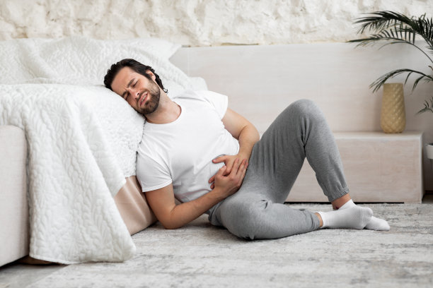 男人在家里的卧室遭受腹部疼痛图片下载