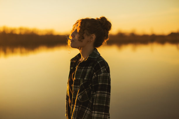卷毛女人吸烟日落背景。轮廓图片下载