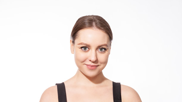 特写工作室的一个有吸引力的年轻白人女子棕色马尾头发对白色背景图片下载