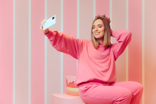 戴着皇冠的寿星在蛋糕上自拍图片下载