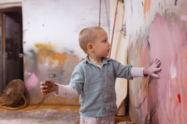 一个艺术家小孩在墙上画画图片下载