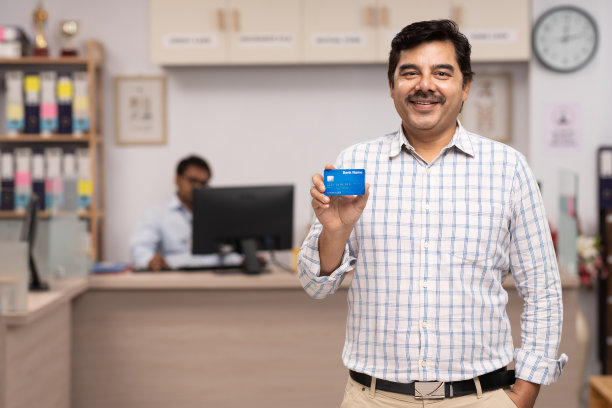 在银行持有信用卡的男性客户肖像。库存图片图片下载