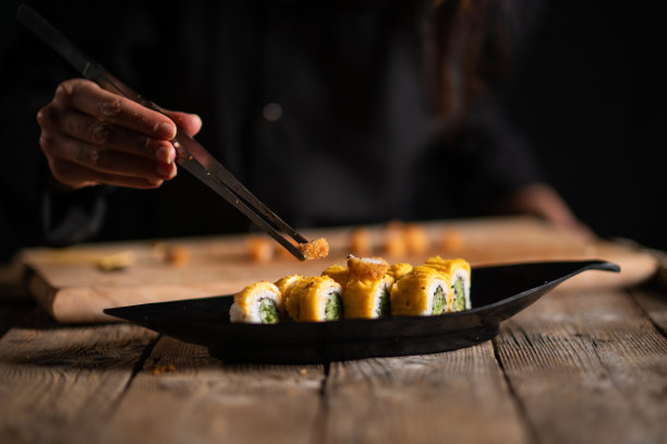 女寿司师傅正在做卷寿司图片下载