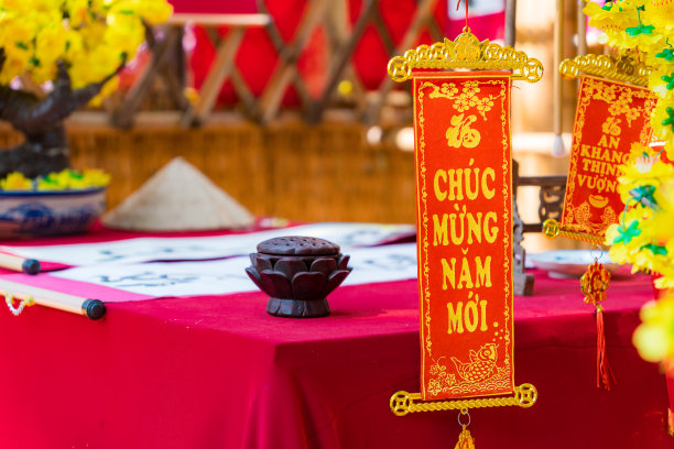 春节期间挂在树上的装饰烟花。传统的越南新年。照片中的文字意味着新年快乐，阖家平安。库存图片图片下载