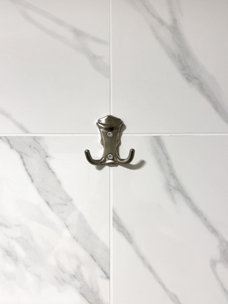 金属吊钩挂在瓷砖墙上图片下载