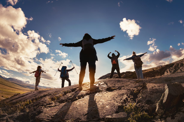 一组剪影在胜利者的姿势对太阳和山脉图片下载