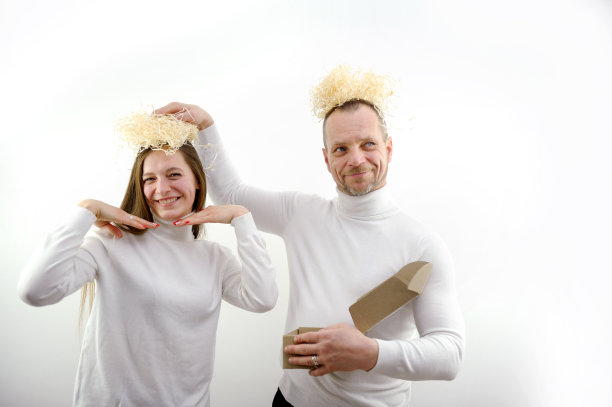 白底上的男人和女孩手里拿着一盒包装材料，假装是天使。有趣送货天使送货开箱。滑稽的人头窝图片下载