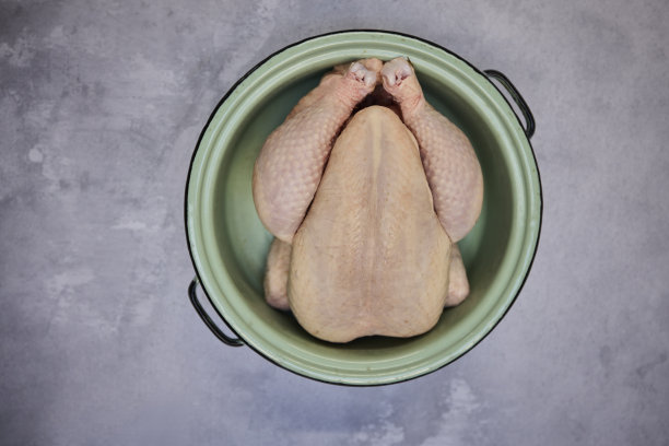 在肉店展示的背景上未煮熟的鸡的头顶镜头图片下载