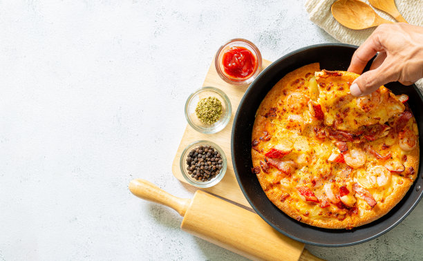 新鲜的生披萨，蘑菇，圣女果，罗勒和帕尔马干酪，放在圆形平底锅里，白色背景，留有复制空间。烘焙前自制披萨图片下载