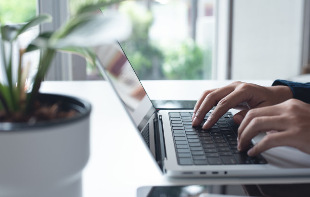 商人在家里办公室的笔记本电脑上工作。休闲商务人士，使用便携式电脑设备的自由职业者，在工作场所的桌子上上网图片下载