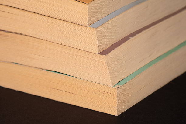 四本黑色背景的平装书。图片下载