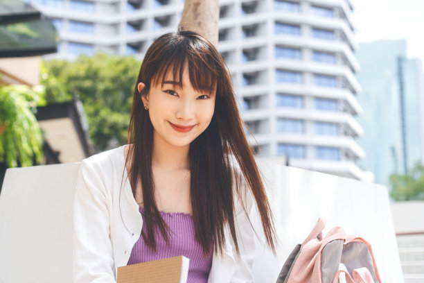 年轻的成年亚洲女学生肖像在户外的一天图片下载