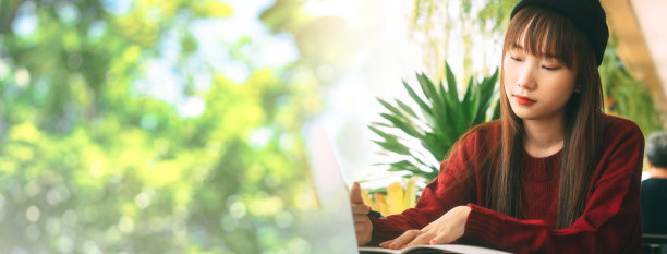 年轻的成年亚洲大学生女子与笔记本电脑学习在咖啡馆横幅大小的背景图片下载