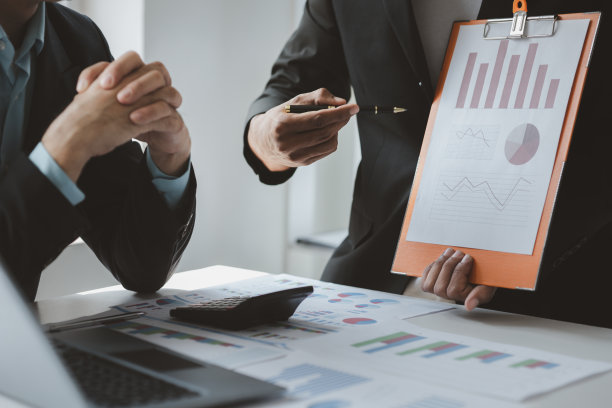 两个商人在一起头脑风暴，审阅财务部门总结的公司财务文件，他们是商业伙伴。工商管理概念。图片下载