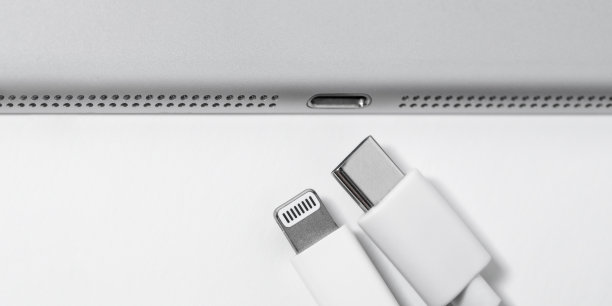 苹果闪电到USB-C线和一个小工具在白色桌子上有空间，特写。做广告的地方。技术的概念。图片下载