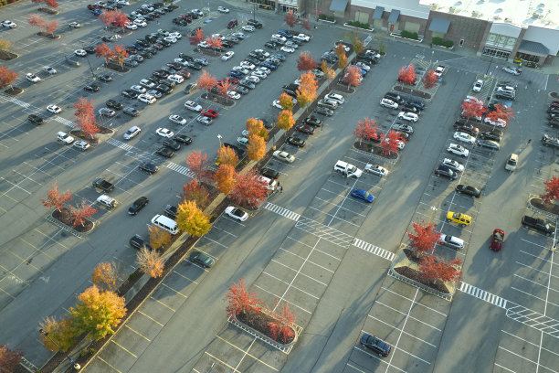 俯视图的许多汽车停在停车场前的一个购物中心广场。消费主义与市场经济的概念图片下载