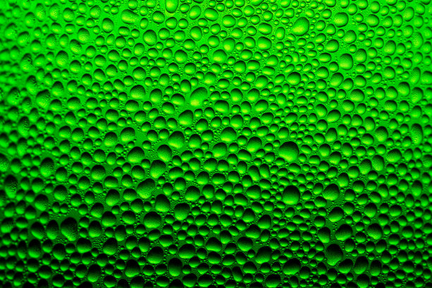 水滴背景在绿色玻璃瓶，纹理水滴在瓶子上图片下载