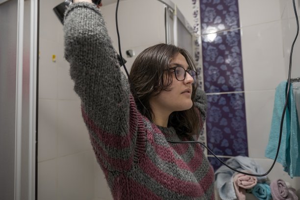 在浴室里拿着吹风机的少女（半身照）图片下载