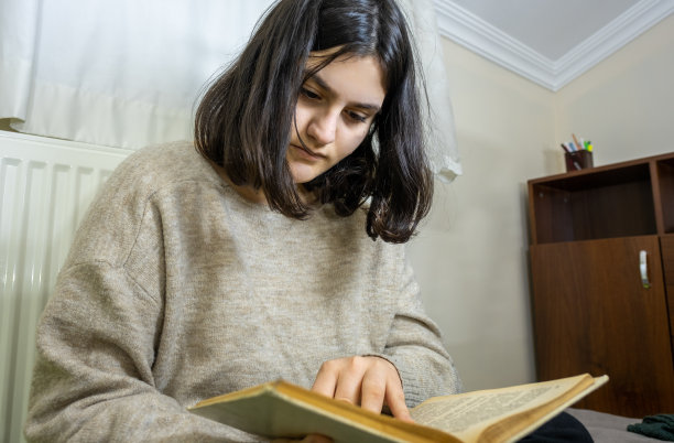 年轻读者在房间里拿着书阅读图片下载