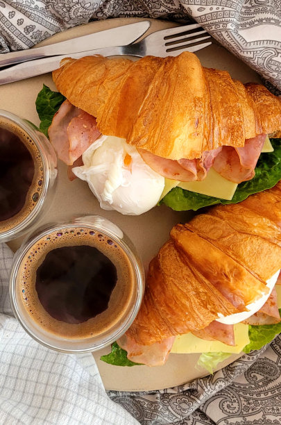 床上早餐-牛角包，火腿，奶酪，鸡蛋和生菜，以及传统的咖啡。这张照片是从上面拍的。图片下载