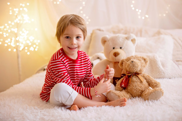 可爱的学龄前男孩，玩着白色和红色的手镯。马氏纱，白色和红色相间的纱线，保加利亚民间传说传统，三月迎春，装饰象征图片下载