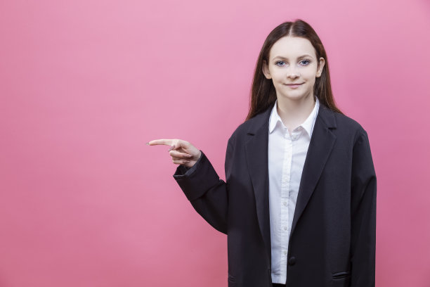十几岁的女孩穿着黑色夹克，微笑的面部表情愉快地孤立在生动的粉红色背景图片下载
