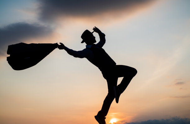 个人成就目标。男子剪影跳上天空背景。自信的商人。每天的动力。享受生活和自然。商业上的成功。自由。是关于自由的图片下载