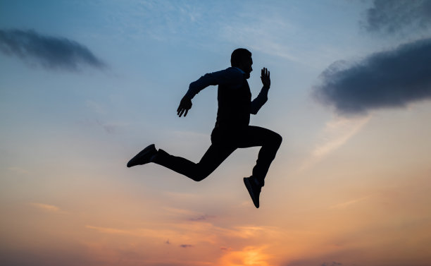 找到你的自由。个人成就目标。男子剪影跳上天空背景。自信的商人。每天的动力。享受生活和自然。商业上的成功。自由图片下载