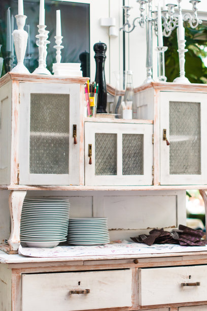 传统的老式厨房，白色橱柜和瓷碗和杯子。白色的盘子互相站着。库存图片图片下载