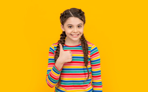 少女竖起大拇指的照片。少年女孩的童年摄影棚。童年的概念。图片下载