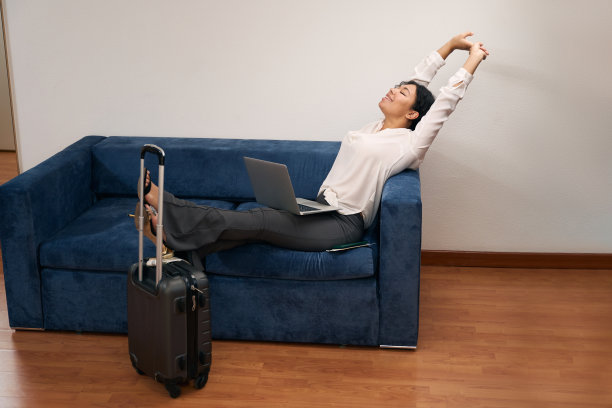 愉快的女游客与笔记本电脑休息在豪华套房图片下载