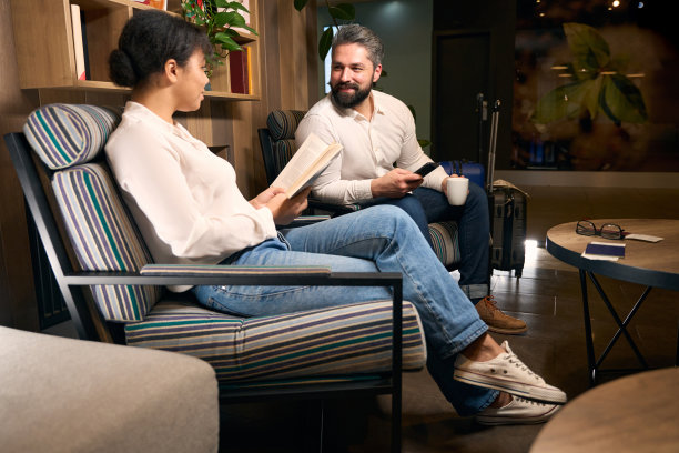 男性和女性在酒店大堂等待办理入住手续图片下载