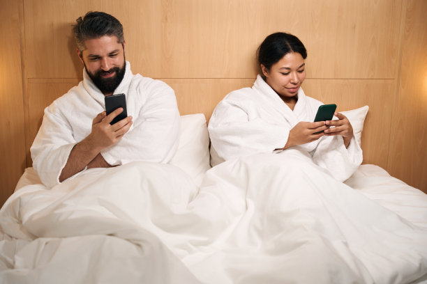 年轻夫妇在酒店房间拿着手机图片下载
