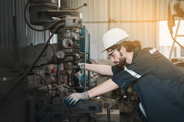 工业工程师在工厂机器上检查和维护机器。工人检查和修理机器。图片下载