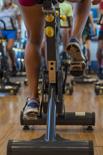 旋转类。教练在自行车上，学生们在她前面。图片下载